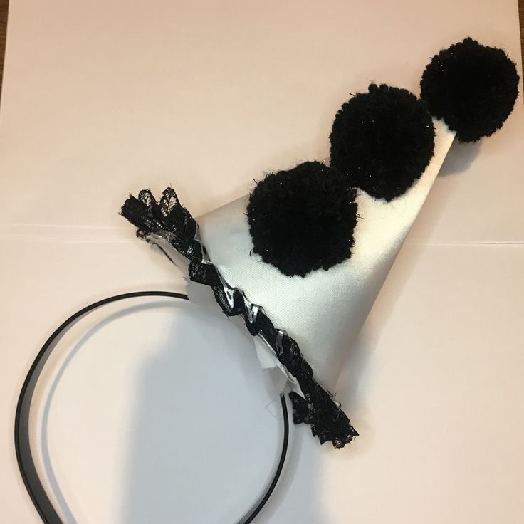 a party hat with black pom - poms on it