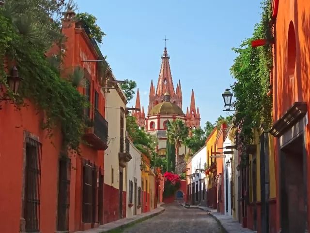 a narrow street with buildings and trees on both sides