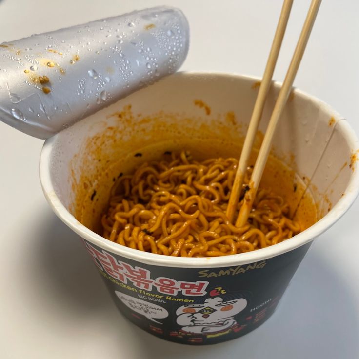 a bowl of noodles with chopsticks sticking out of it