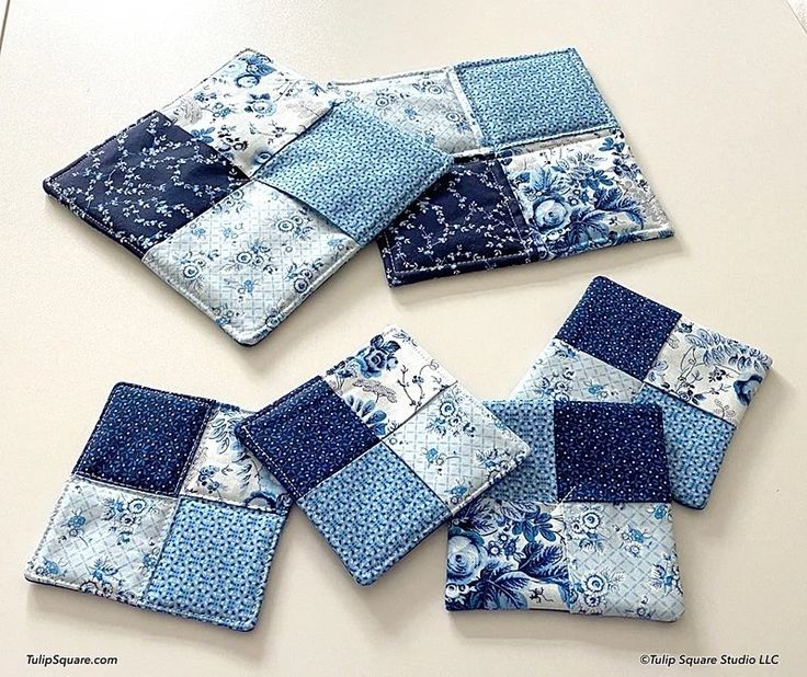 blue and white patchwork coasters sitting on top of a table