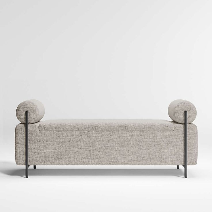 an upholstered bench with metal legs and back rests against a plain white wall