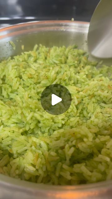 a bowl filled with green rice being stirred by a ladle to make it look like food