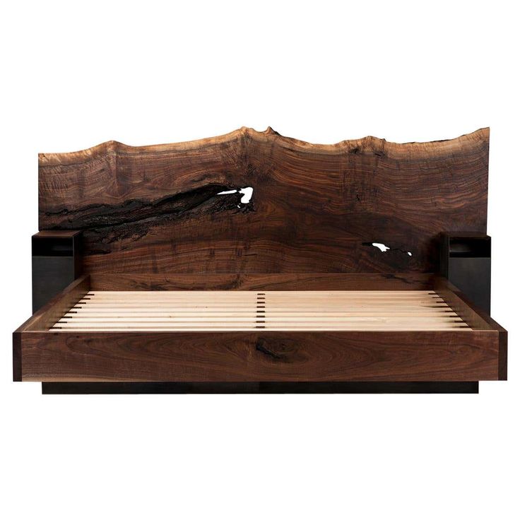 a bed with wooden headboard and foot board in the shape of a tree trunk