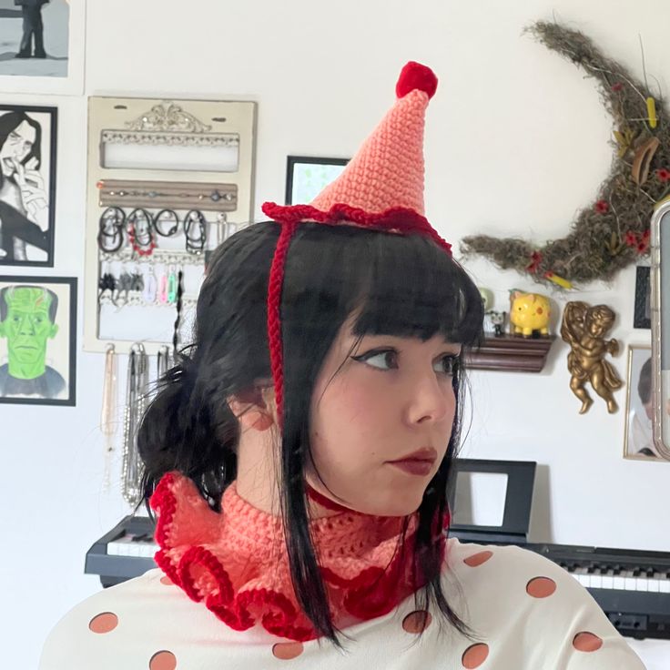 a woman wearing a red and white polka dot dress with a pink hat on her head