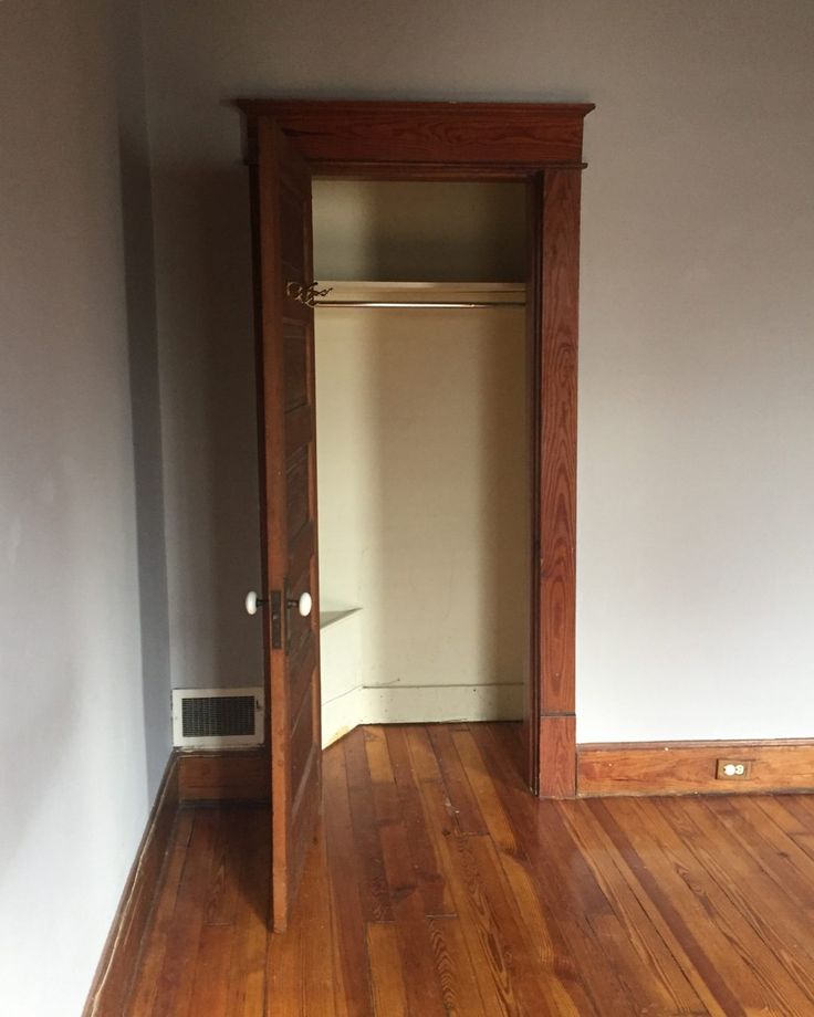 an empty room with hard wood floors and white walls