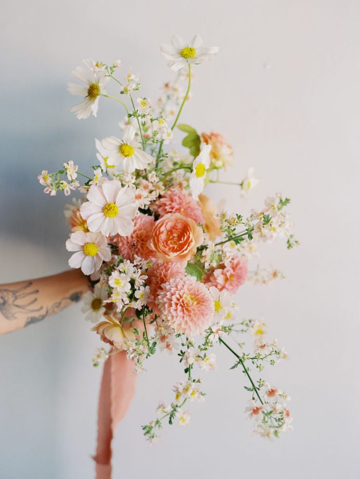 a person holding a bouquet of flowers in their hand