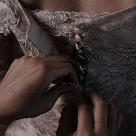 the woman is fixing the lace on her dress