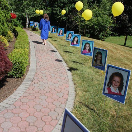 a woman walking down a brick path with pictures on it and balloons in the air