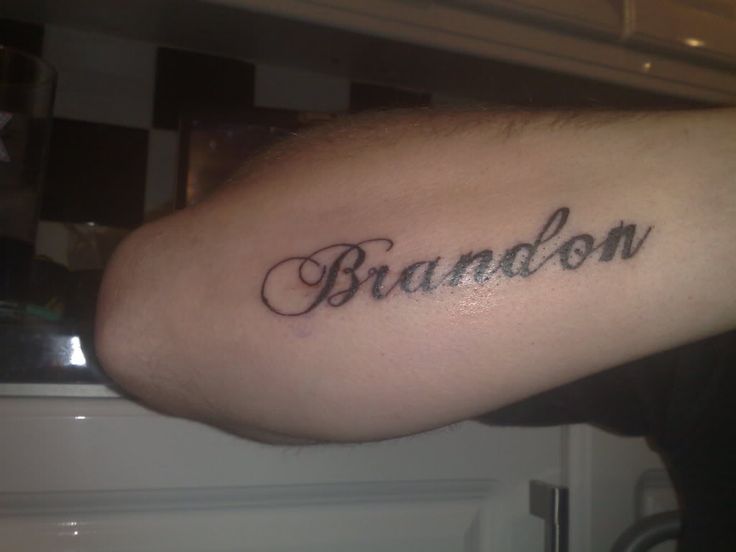 a man's arm with the word brandon written on it in cursive font