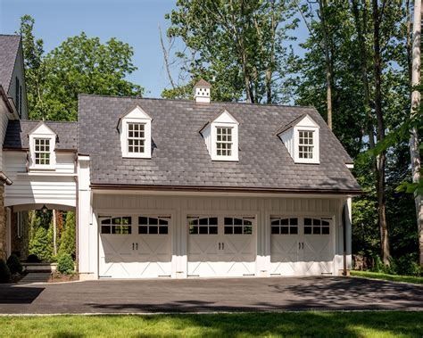 a two car garage with three windows on the top floor and one above the door