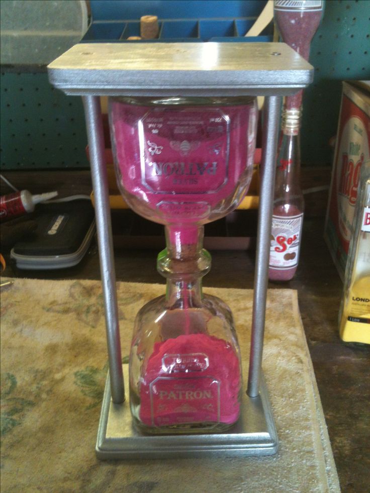 a pink glass bottle sitting on top of a metal stand