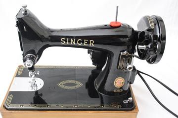 an antique singer sewing machine on a wooden stand with the words singer written on it