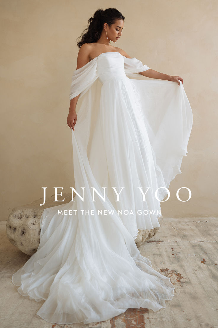 a woman in a white dress standing on a wooden floor