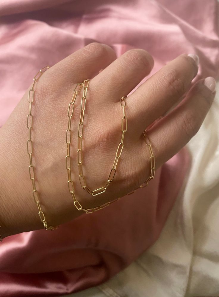 This Solid 14k Paper Clip gold Bracelet looks great when worn by itself or with your favorite charms. It's a Basic Piece of Jewelry that everyone must have in their jewelry collection. Available: In 14k Yellow, White, and Pink Gold Chain style: Paper Clip Link Size: 5x3 mm Lock: Lobster Claw Length: 61/2 to 7 inches Made In New York Available: In different lengths please select options Made to Order: Please allow 5-10 days to process your order 14k Gold Rectangular Paperclip Chain Bracelet, Gold Sterling Silver Link Paperclip Bracelet, Gold Sterling Silver Chain Bracelet With Lobster Clasp, Gold-tone 14k Gold Chain Bracelet As Gift, 14k Gold-tone Chain Bracelet As Gift, Gold Sterling Silver Jewelry With Rectangular Links, Minimalist 14k Gold Jewelry With Rectangular Links, Timeless Yellow Gold Paperclip Bracelet As Gift, Timeless Yellow Gold Paperclip Bracelet Gift