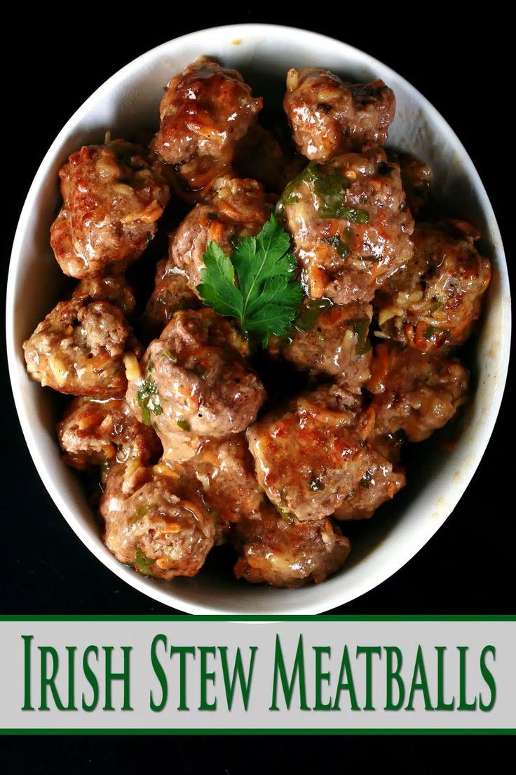 a white bowl filled with meatballs and garnished with parsley