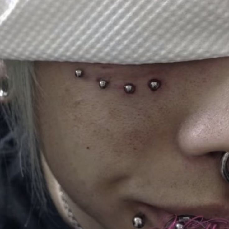 a woman with piercings on her face and nose