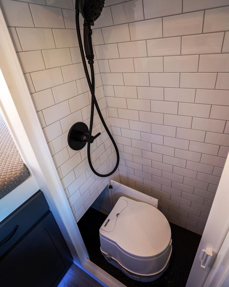 a white toilet sitting in a bathroom next to a shower head