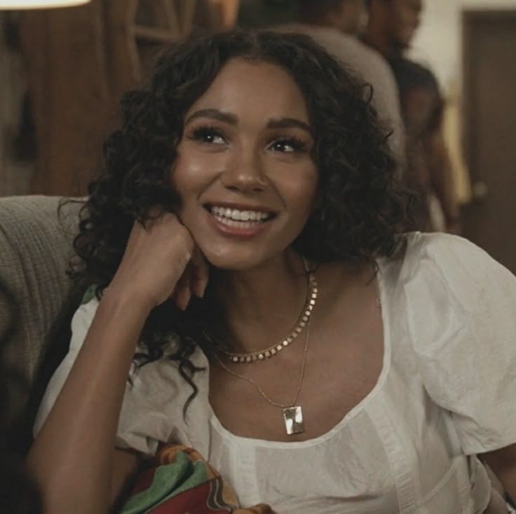 a woman sitting on top of a couch smiling