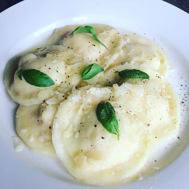 some food on a white plate with green leaves