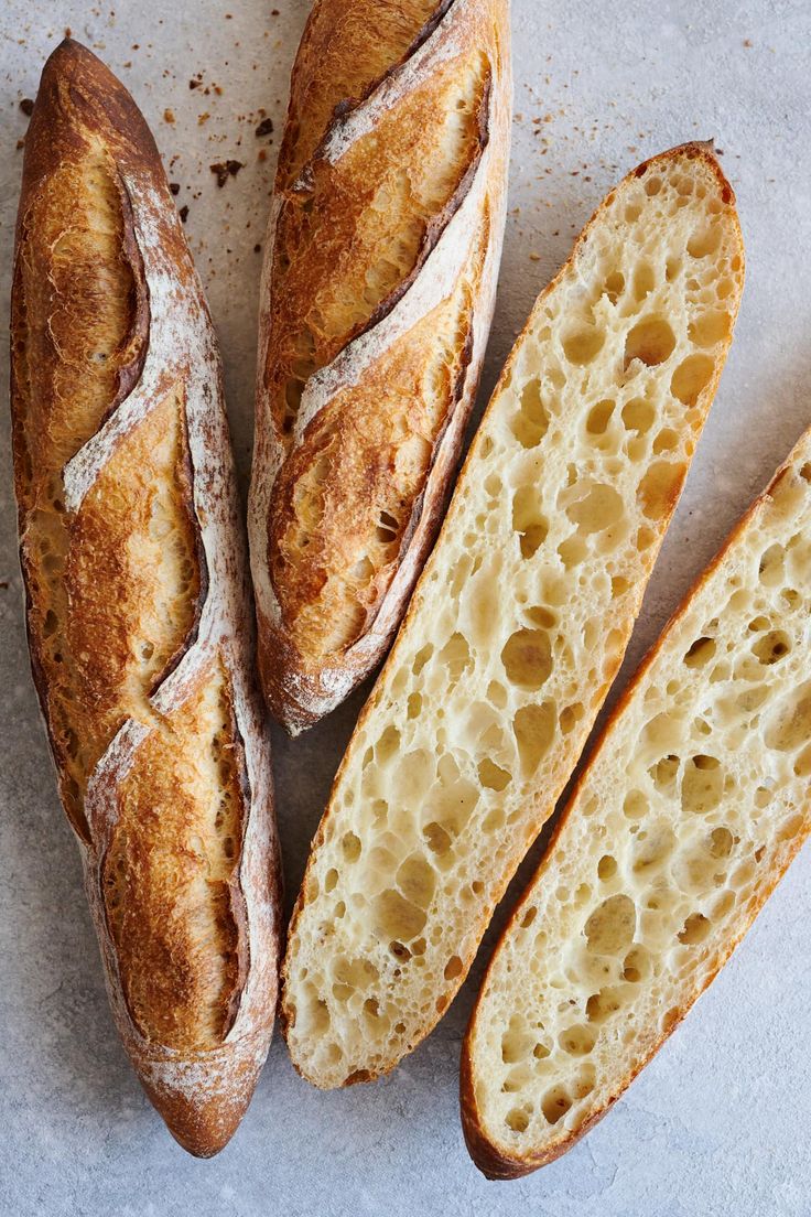 three loaves of bread sitting next to each other on top of a white surface