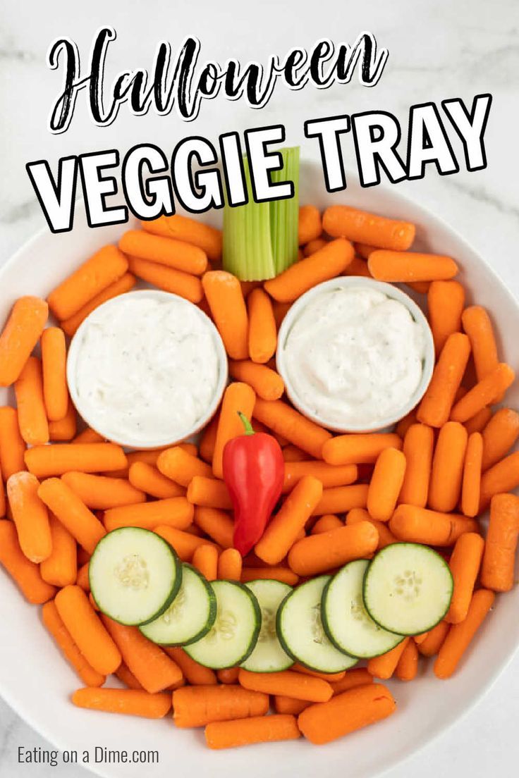 a white plate topped with carrots and cucumbers next to a face made out of veggies