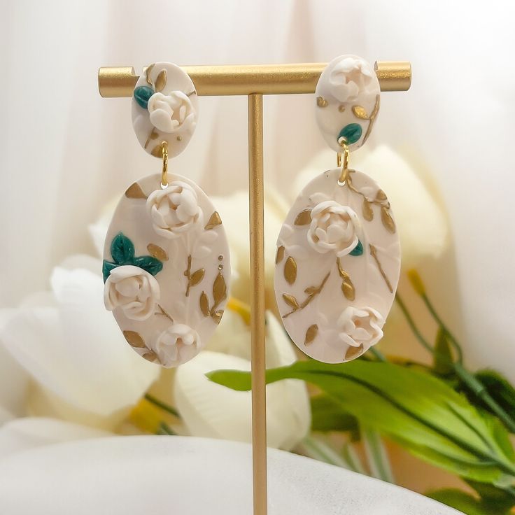 Step into summer with our exquisite Evangeline Earrings, where artistry and elegance bloom. Crafted from polymer clay, each earring showcases intricate 3D floral designs adorned with delicate gold leaf accents, capturing the essence of a summer garden in full bloom. The hypoallergenic gold filled posts ensure comfort for all-day wear, making them perfect for summer outings, weddings, and special events where you want to shine. Elegant Floral Print Earrings, Gold Flower-shaped Polymer Clay Earrings, Elegant Flower Earrings With Floral Print For Gift, Elegant Floral Print Flower Earrings For Gift, Elegant Floral Print Flower Earrings As Gift, Gold Jewelry With 3d Flowers In Polymer Clay, Gold Polymer Clay Jewelry With 3d Flowers, Elegant Floral Print Drop Earrings, Handmade Gold Flower Earrings In Polymer Clay