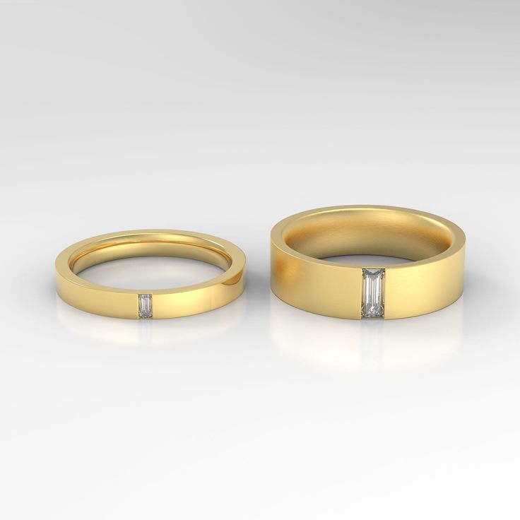 two gold wedding bands with diamonds on them