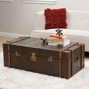 an old trunk sitting on top of a rug in front of a white couch