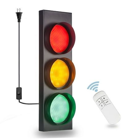 a traffic light with a remote control attached to it's side and an electronic device connected to the stoplight