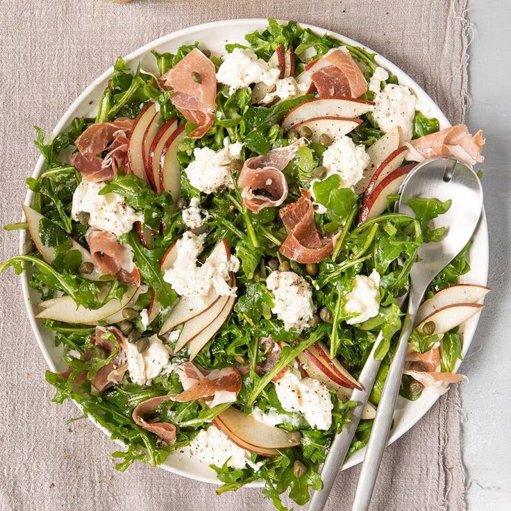 a white plate topped with salad and nuts