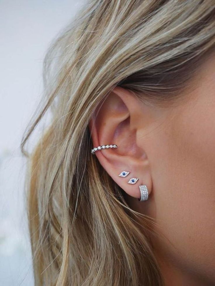 a woman wearing three different ear piercings