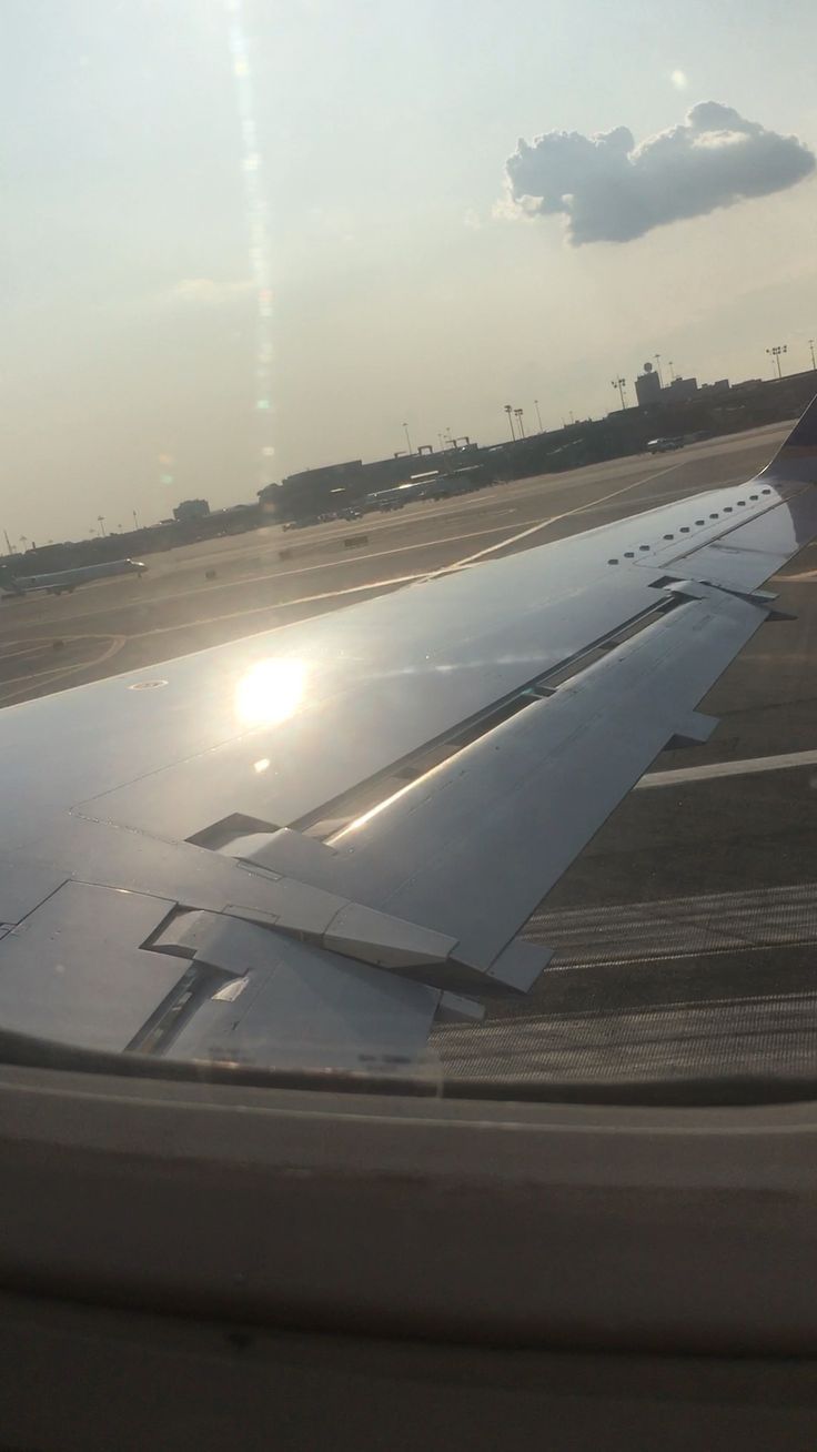 an airplane wing with the sun shining through it