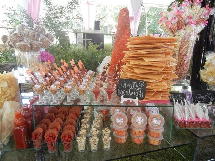 an assortment of desserts on display in a glass case at a wedding or baby shower