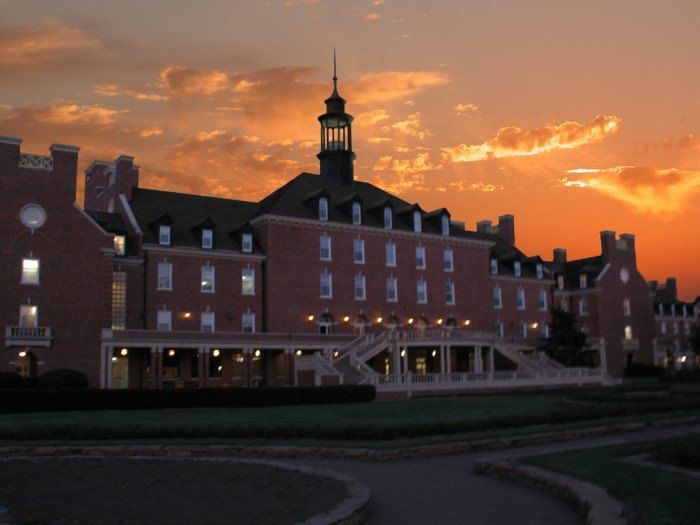 the sun is setting in front of a large building