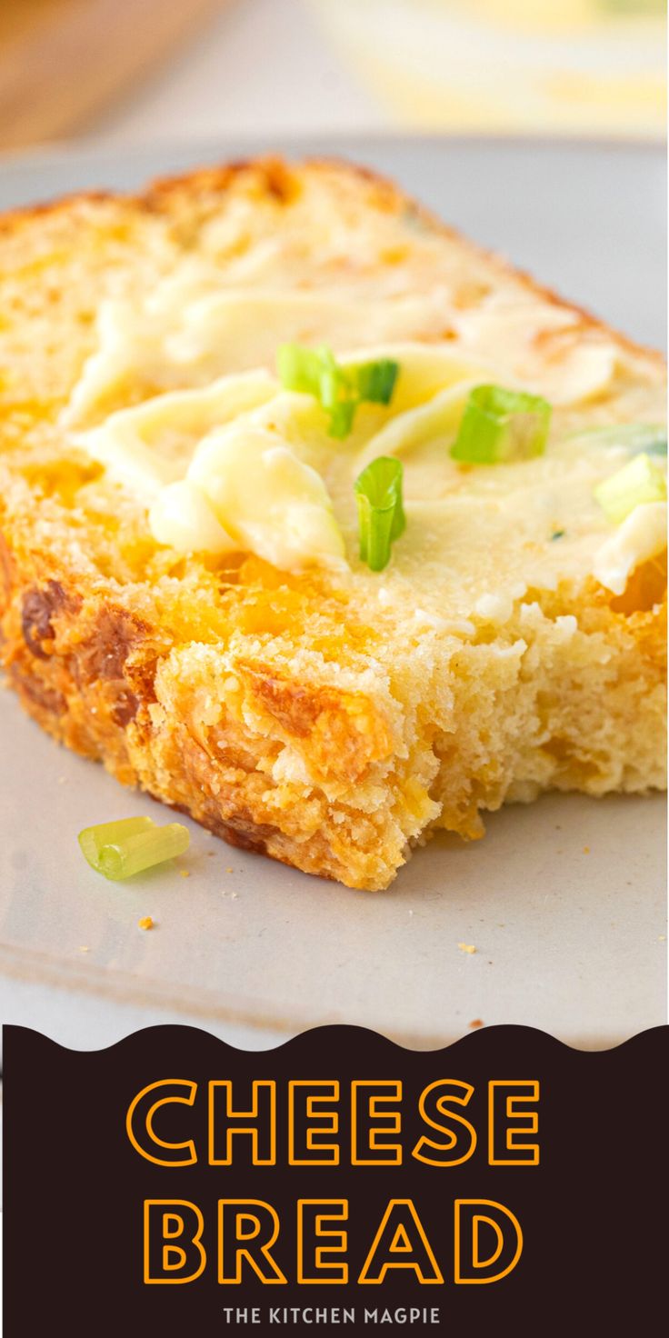 a close up of a piece of bread on a plate with cheese and green onions