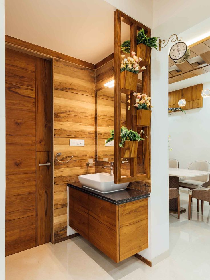 a bathroom with wood paneling and a sink in the corner next to a mirror