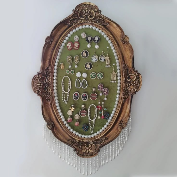 there is a wall hanging with many different items in the frame and beads on it