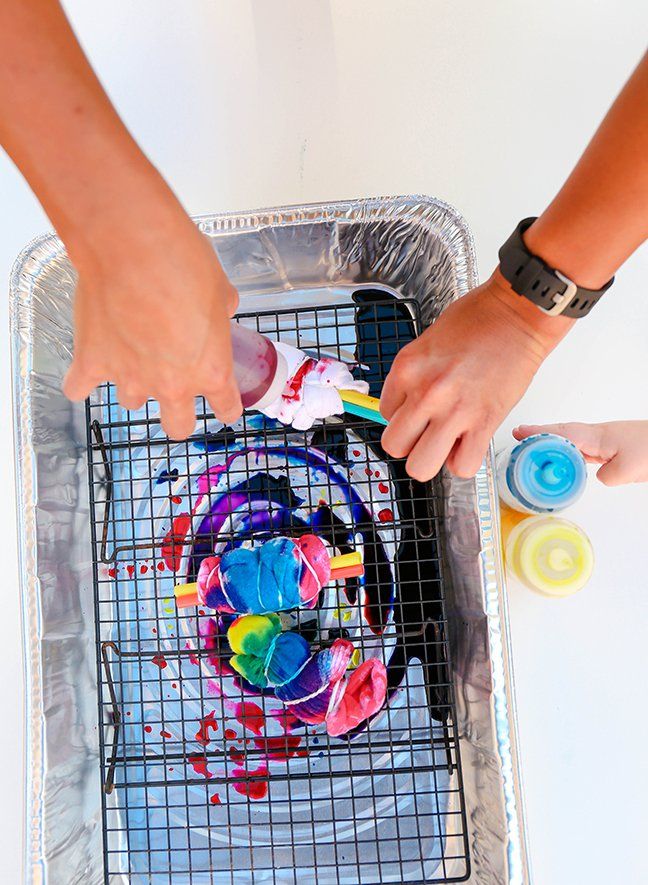 two people are painting on a metal tray