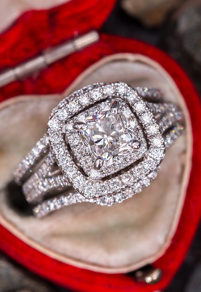 a diamond ring sitting in an open red velvet box