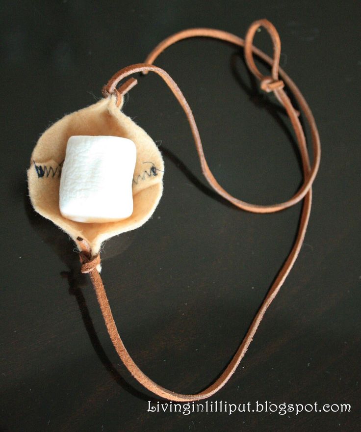 an electronic device with a cord attached to it on a black surface and brown leather strap