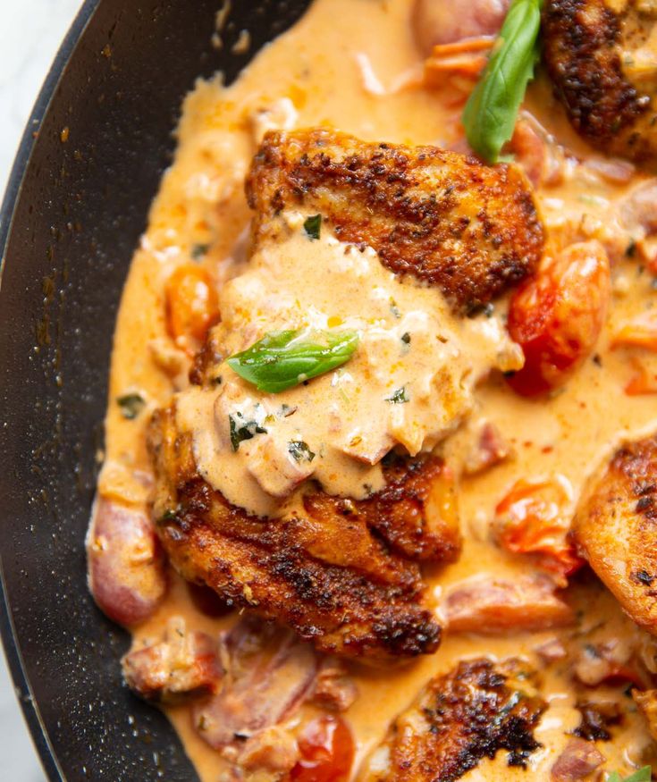 a skillet filled with meat and cheese covered in gravy on top of a table