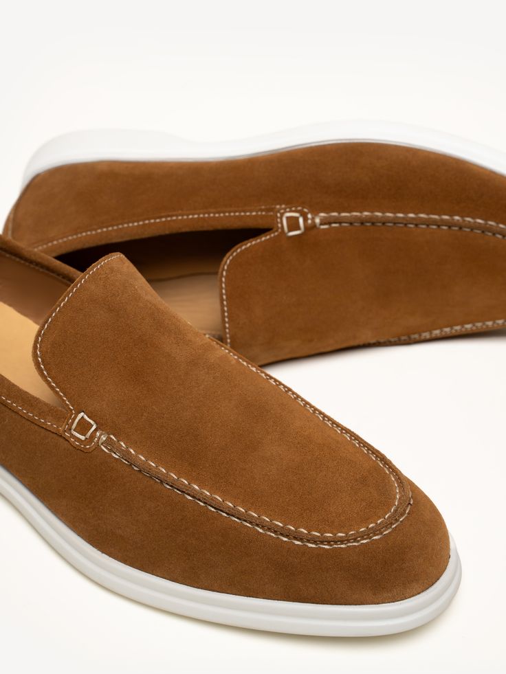 An ultra-soft kid suede upper and durable rubber sole come together for the ultimate hand-stitched loafer. With a sole that contrasts in color, the style pairs equally well with a pair of jeans as it does a suit—all year long. Suede Slip-ons With Plain Toe, Suede Slip-ons With Leather Sole And Plain Toe, Suede Slip-on Sneakers With Leather Sole And Round Toe, Classic Suede Slip-ons With Stitched Sole, Suede Low-top Moccasins With Contrast Sole, Business Casual Moc Toe Loafers With Contrast Sole, Suede Slip-on Boat Shoes With Suede Lining, Slip-on Stitched Sole Low-top Moccasins, Slip-on Moccasins With Suede Lining And Plain Toe