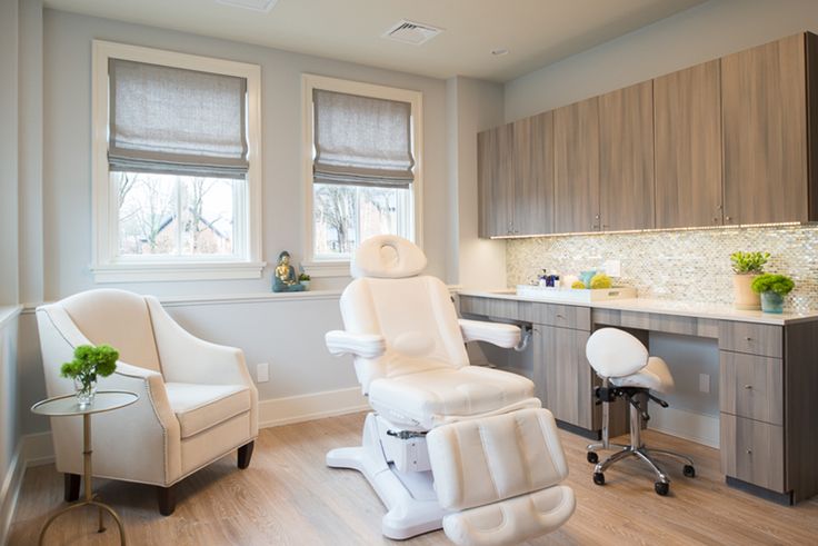 a white chair sitting in front of a window next to a sink and counter top