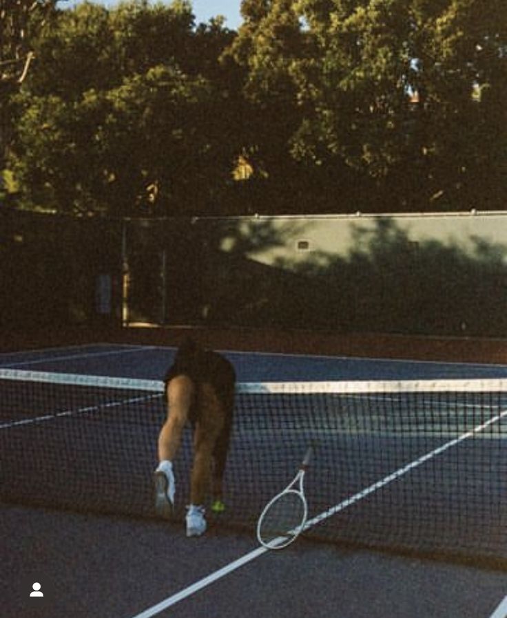 a man standing on top of a tennis court holding a racquet