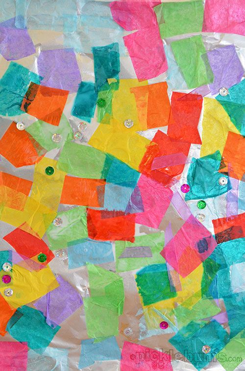 colorful pieces of paper with buttons and holes in them on a sheet of plastic wrap