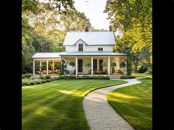 a white house with a large yard and walkway leading to the front door is surrounded by lush green trees