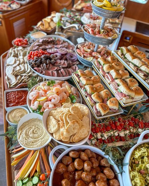 a buffet table filled with lots of different types of food and dips on it