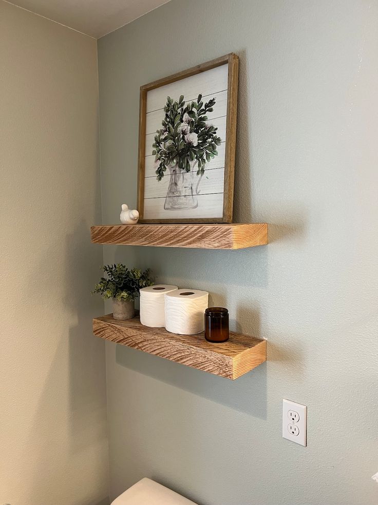 two wooden shelves above a toilet in a bathroom