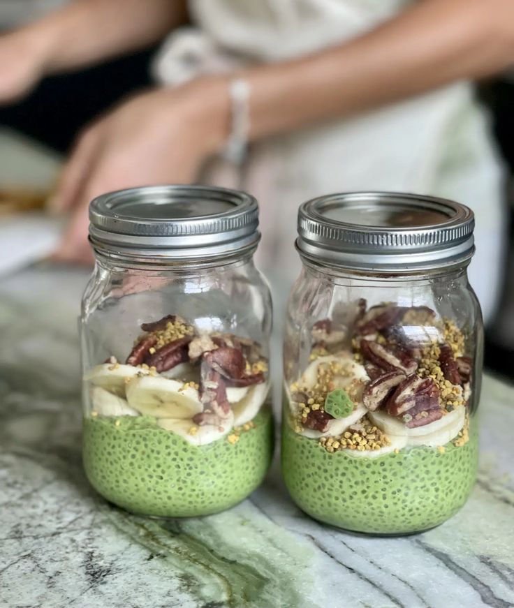 two jars filled with food sitting on top of a table