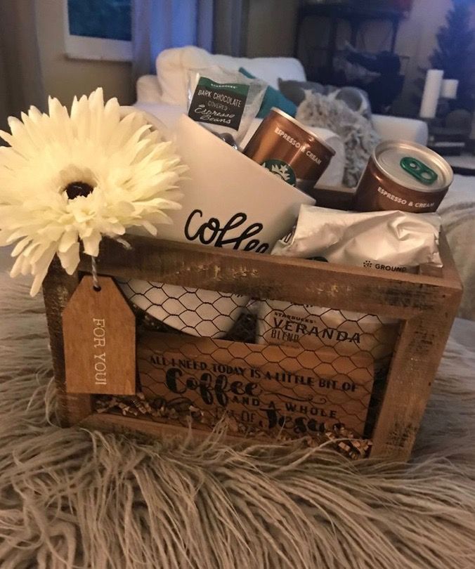 a wooden crate filled with coffee and other items on top of a fur covered bed